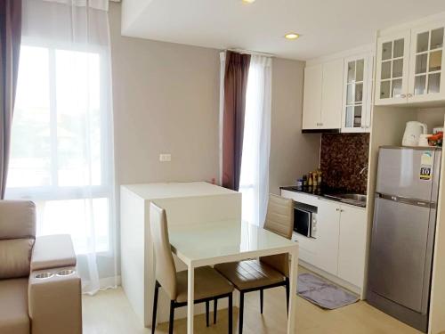 a small kitchen with a table and a refrigerator at Chic 1BR near WON Beach Bangsaen in Bangsaen