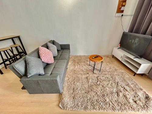 un salon avec un canapé et une télévision dans l'établissement Cozyindah11A#7pax#netflix#NearAeonAlma#BukitMertajam, à Bukit Mertajam