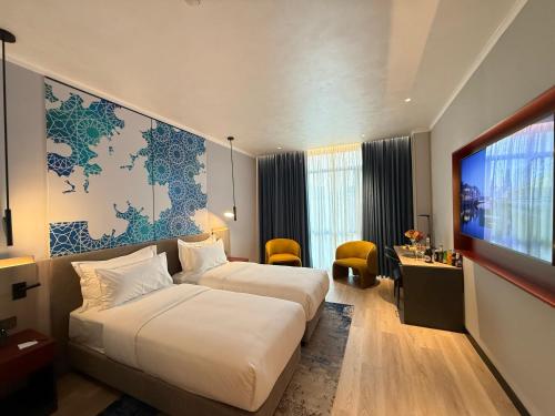 a hotel room with two beds and a flat screen tv at Khorazm Hotel in New Uzbekistan Park in Teshabayguzar