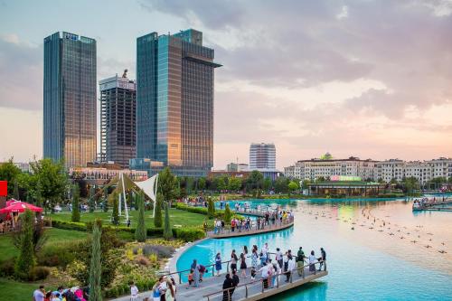 un groupe de personnes marchant sur un pont sur une rivière dans l'établissement Tashkent City Apartments D11, à Tachkent
