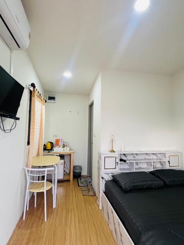 a bedroom with a bed and a table and a desk at Thung Setthi Homestay&Cafe2 in Chiang Dao