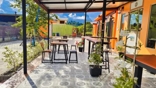 a patio with tables and stools and tables at ทุ่งเศรษฐีโฮมสเตย์แอนด์คาเฟ่ in Chiang Dao
