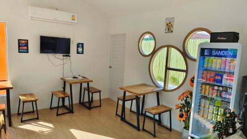 um quarto com geladeira, banquetas e uma TV em ทุ่งเศรษฐีโฮมสเตย์แอนด์คาเฟ่ em Chiang Dao