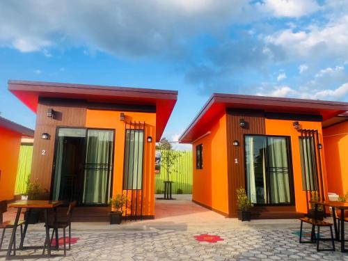 a row of colorful houses with tables and chairs at Thung Setthi Homestay&Cafe2 in Chiang Dao