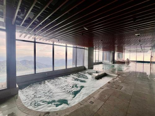 a large swimming pool in a building with windows at Antara Genting by J&H 2BR Karaoke K1 in Genting Highlands