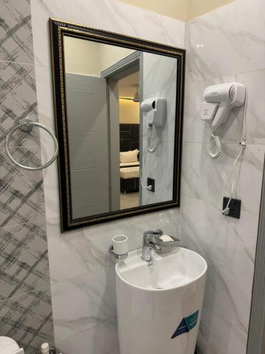 a bathroom with a sink and a mirror at Hotel white season Gulberg in Lahore