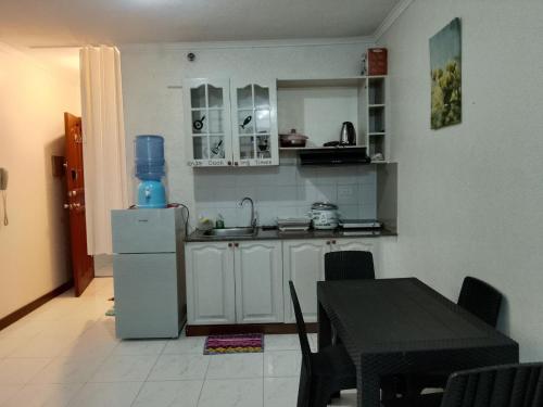 Una pequeña cocina con una mesa y un refrigerador. en Albergo Hotel Unit near Wright Park, The Mansion, Minesview & Botanical Garden, en Baguio