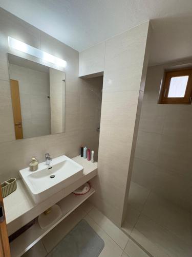 une salle de bain avec un lavabo et un miroir dans l'établissement DoMi panorama&wellness, à Dudince