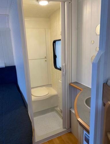a small bathroom with a toilet and a sink at Aurora Caravan Near Bergen - NO shower in Strusshamn