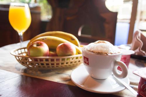 Una taza de café y una cesta de fruta sobre una mesa. en B&B on the Sabie, en Sabie