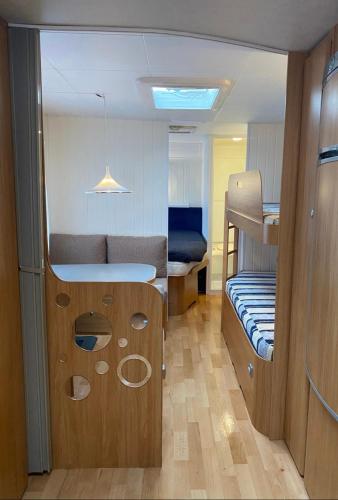 a small room with a bunk bed and a bedroom at Aurora Caravan Near Bergen - NO shower in Strusshamn