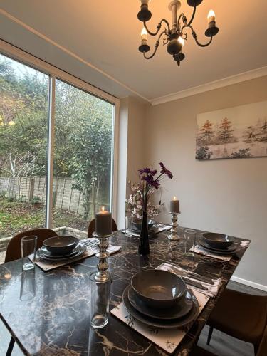 a dining room with a table and a large window at Charming 3 BR - NEC HS2- Long Stays Wifi Parking Airport in Shirley