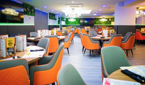 een eetkamer met oranje stoelen en tafels bij The Old Court House in Kingswinford