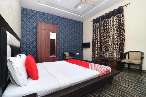 a bedroom with a bed with red and white pillows at Hotel O B1 in Kartārpur