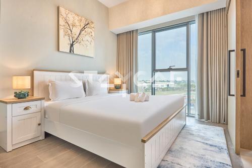 a bedroom with a large white bed and a large window at Staycae Holiday Homes Golf Gate - Damac Hills in Dubai