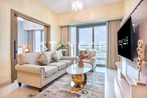 a living room with a couch and a table at Staycae Holiday Homes Golf Gate - Damac Hills in Dubai