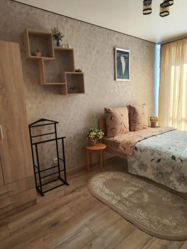 a bedroom with a bed and a table with a rug at Апартаменты у новому будинку біля Либідь Плази-Ощадбанк in Khmelʼnytsʼkyy