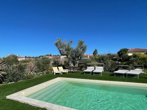 a swimming pool in a yard with lounge chairs at L'Escale au Portugal Villa-B&B-Spa in Ataíja de Baixo