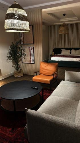 een kamer met een bed, een tafel en een bank bij Najdeh Suite, our goal is to make you comfortable in Jeddah
