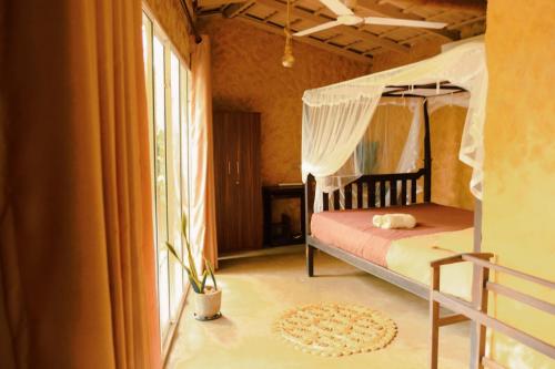a bedroom with a canopy bed and a window at Ashok villa in Weligama