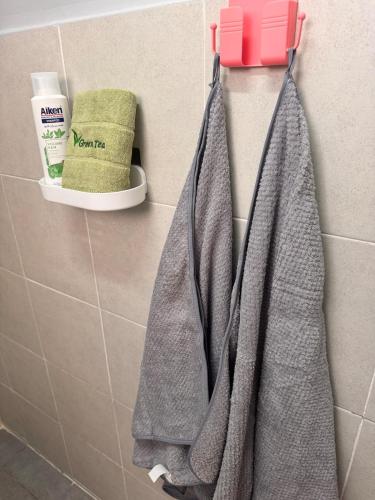 a bathroom with two towels hanging on a wall at Comfy Hut-KLIA SEPANG in Sepang