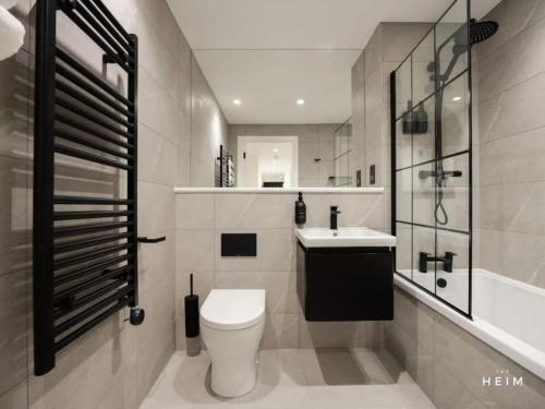 a bathroom with a toilet and a sink and a shower at Pappilo at The Heim Residences in Manchester