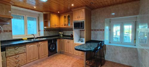 a kitchen with wooden cabinets and a sink and a stove at VUT 85 Teclas in Puebla de Sanabria