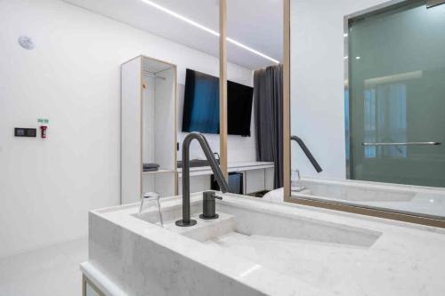 a bathroom with a sink and a bath tub at Pyeongtaek Hotel The Gray Songtan 