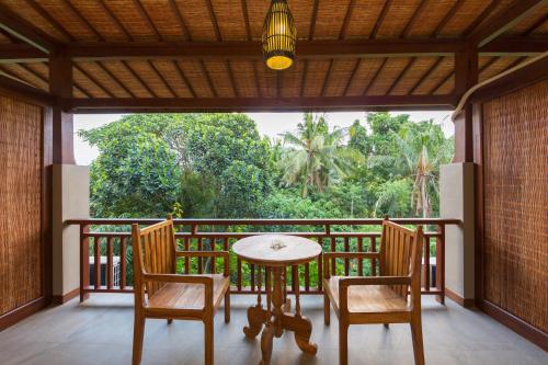 a table and chairs on a balcony with a view at Alamdini Resort Ubud in Ubud
