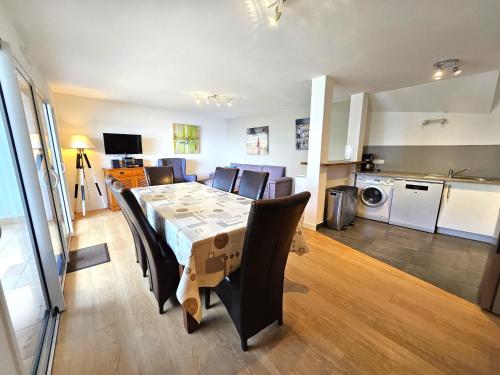 ein Esszimmer mit Tisch und Stühlen und eine Küche in der Unterkunft Résidence Brise de Mer - 2 in Port Nayalo