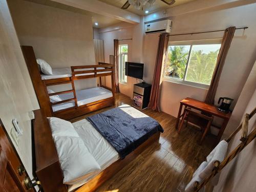 a bedroom with a bunk bed and a desk at Gloria Beach House - Baler in Baler