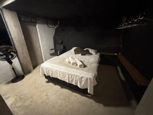 a bedroom with a bed in a dark room at Mirante de itaipava in Itaipava