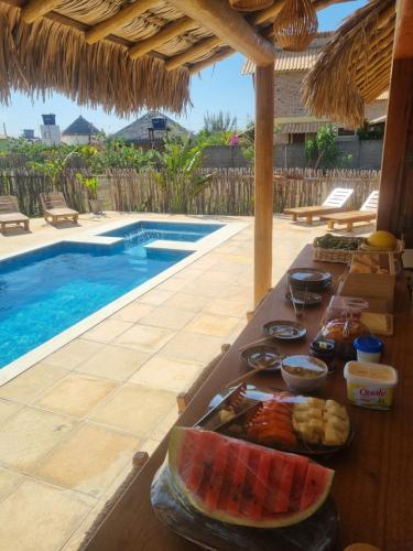 un vassoio di cibo su un tavolo accanto alla piscina di Boogieloop Kite Cabanas a Luis Correia