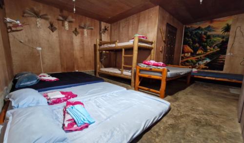 a bedroom with two bunk beds and a chair at J Travel Trail Homestay in Hubangon, Camiguin in Mahinog