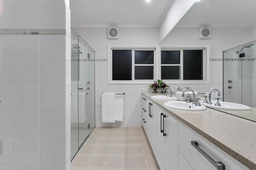 a white bathroom with two sinks and a shower at Luxury Resort Studio Apartment Retreat with Pool, Tennis & Alfresco 