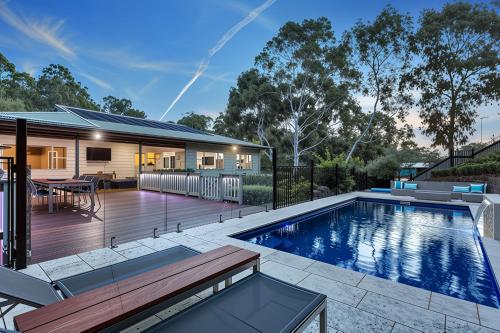 a home with a swimming pool and a deck with a house at Luxury Resort Studio Apartment Retreat with Pool, Tennis & Alfresco