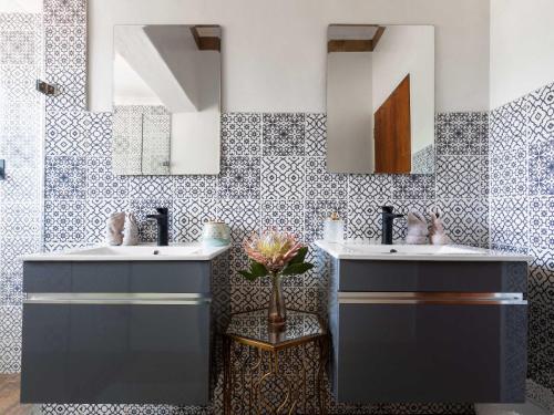 deux lavabos dans une salle de bain avec deux miroirs dans l'établissement Franschhoek Farm Cottages, à Swiss Farm