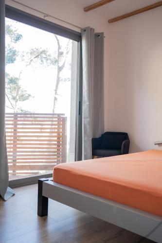 a bedroom with a bed and a large window at Villa vu mer et étang de thau in Sète