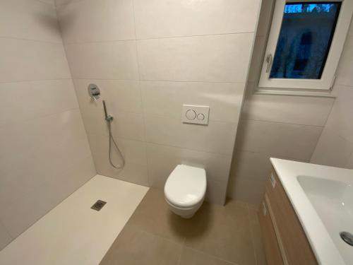 a white bathroom with a toilet and a sink at Apartment Laura in Jenig