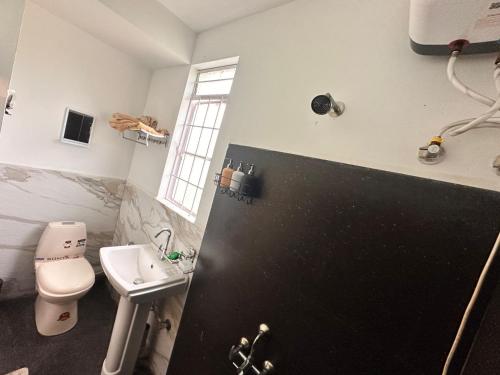 a bathroom with a white toilet and a sink at Ri Tngen - A slice of nature by the Umiam lake! in Borpāni