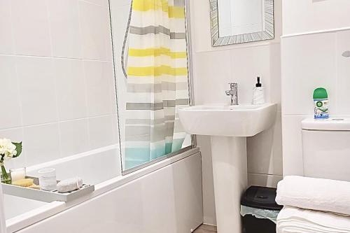 ein Badezimmer mit Waschbecken, Toilette und Spiegel in der Unterkunft 2 Bed House Sleeps 4 - Private Garden Parking in Coventry