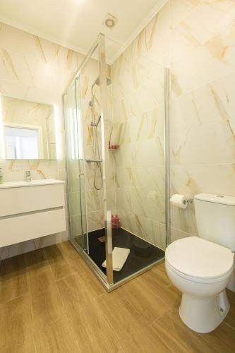a bathroom with a shower and a toilet and a sink at Modern 2BR House Near Tavira Castle in Tavira