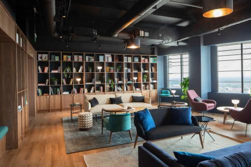 ein Wohnzimmer mit Sofas und Stühlen sowie einem Bücherregal in der Unterkunft StayCozy in Croydon in Croydon