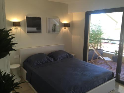 een slaapkamer met een bed en een groot raam bij Appartement Residence Athena in Cannes