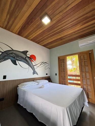 a bedroom with a dolphin painting on the wall at Suítes da Sereia in Cananéia