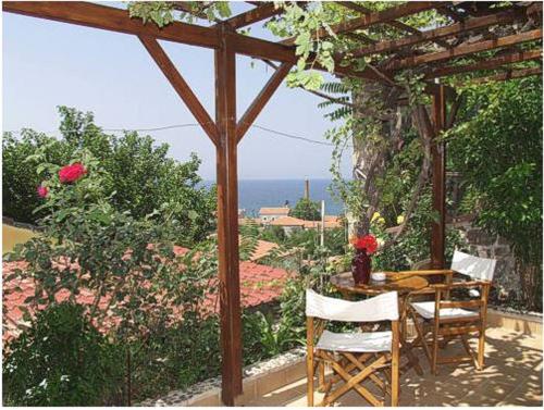 a table and chairs sitting under a wooden pergola at Lela's Kaptani Studio in Mithymna
