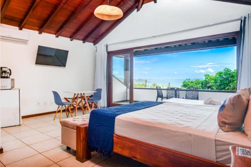 a bedroom with a bed and a balcony at Ilha Branca Exclusive Hotel in Búzios