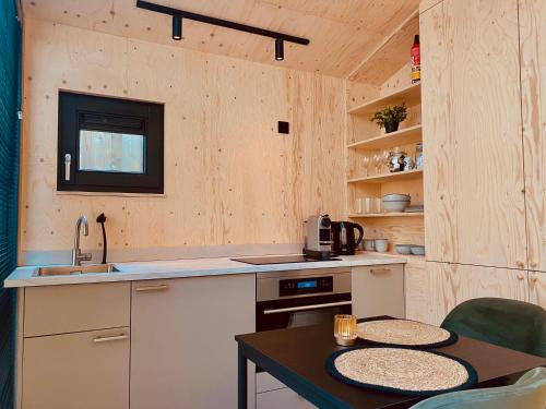 a kitchen with a sink and a table with chairs at Tiny House The Wave in Ons Belang