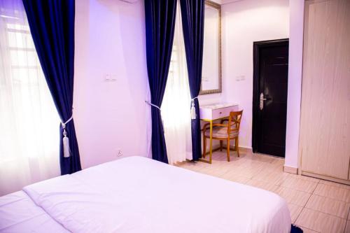 a bedroom with a bed and a desk and a window at Citadel Royal apartment in Lekki