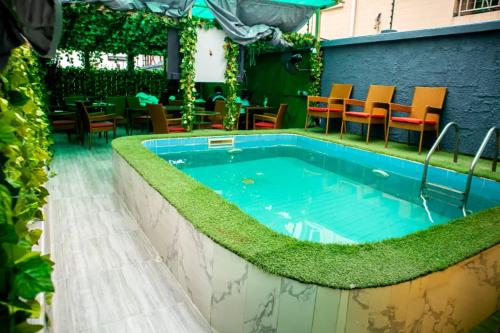 a swimming pool with grass on the side of a building at Citadel Royal apartment in Lekki